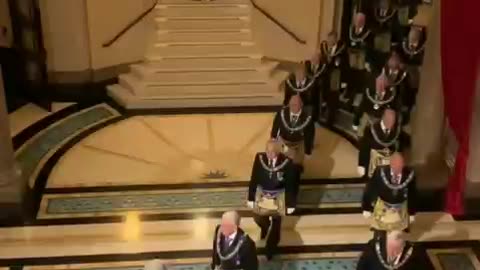 The illuminati in aprons walk in a strange formation