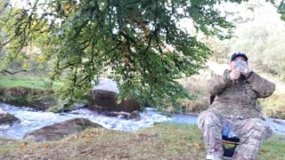 Eating a sausage tortilla by a river. Cooked on a campfire.