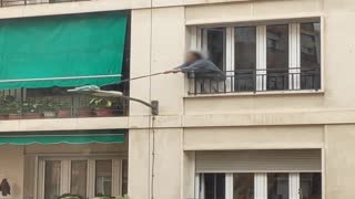 Woman Scrubs Lamppost from Her Apartment Window