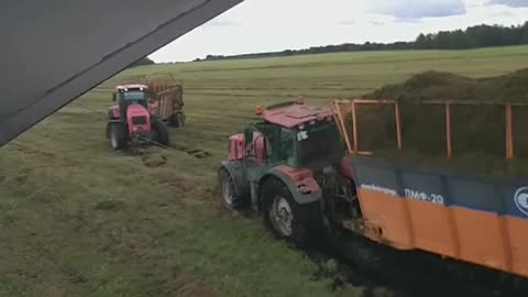 A trailer with grass overturned on the field