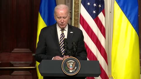 Biden reads his answer to a reporter's question directly from a script in front of him
