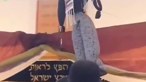 Israeli settlers celebrating as they hang a doll adorned with a Palestinian Kefiyyeh