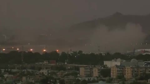 Live shot captures smoke and gunfire following Kabul airport bombing.