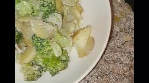 Potatoes and broccoli in oven with minced meat in pan