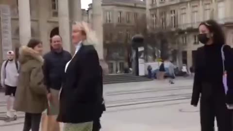 The reactions of the French people towards someone waving a Russian flag in a busy main street