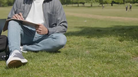 Handheld Shot of Student Working In Park