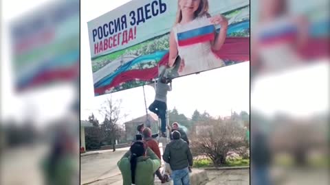 Watch: Russian billboard is torn down near Kherson