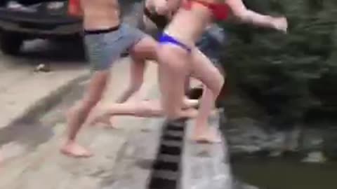 Guy tricks two girls into jumpin off bridge while he takes step back and does not jump