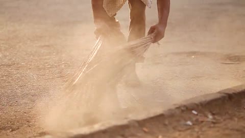 Person Sweeping the Floor Using Brooms