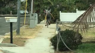 Guy yellow boogie surf board riding down street on unicycle