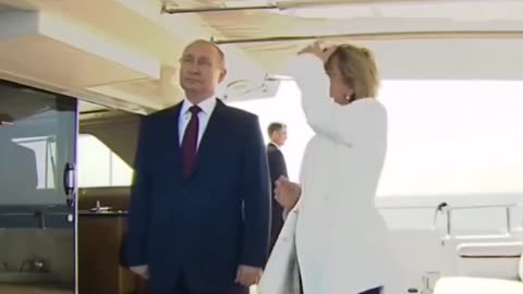 Putin gesturing a talkative host not to speak while the national anthem is being played.