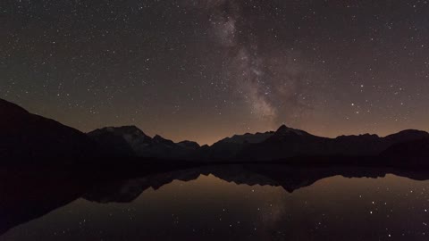Beautiful timelapse of the night sky with lake's reflection