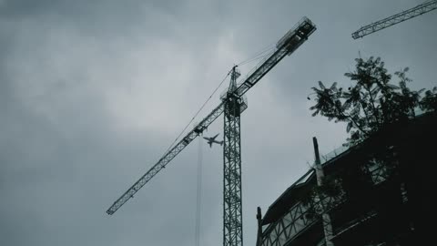 Construction crane with an airplane flying past