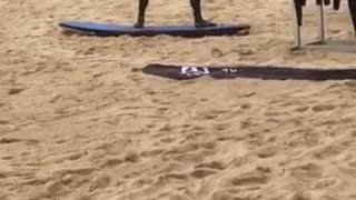 Man in black wet suite practicing on surf board