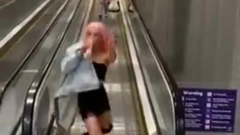 Girl Falls While Walking Off Airport Escalator