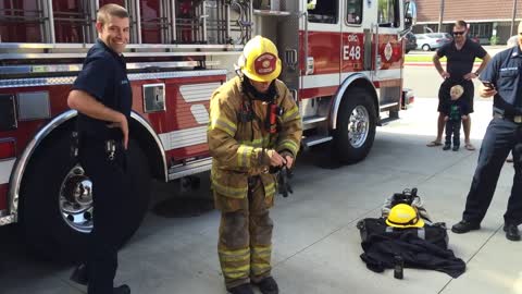 Fireman Demonstrates How He Puts On His Protective Equipment