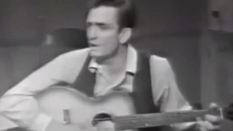 Johnny Cash, on a talk show, shoes off, chain-smoking, high, sings about his farm flooding in 1937