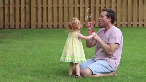 A little girl playing with her father.