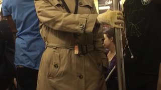 Old man in glasses and trench coat on train