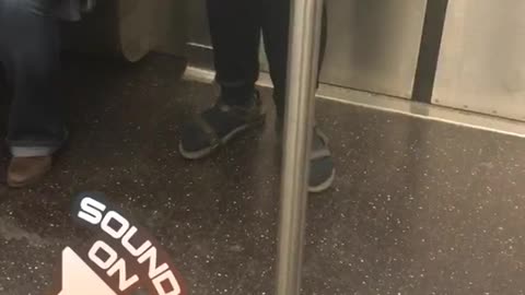 Person with black satchel bag singing loudly on subway