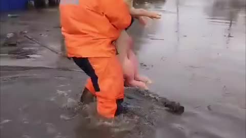 Firemen Carry Russian Soldiers to Safety During Flood