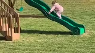 Little Girl Keeps Slipping While Trying To Climb Up Slide