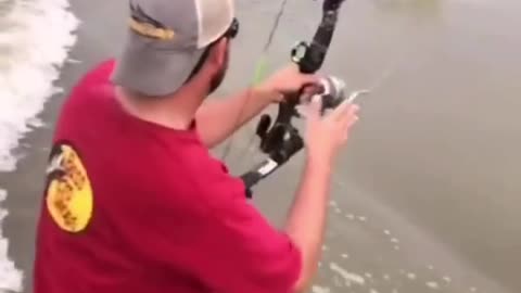 dude shoots jumping carp with bow and arrow