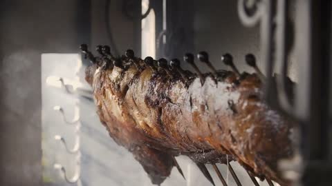 A Close-up of carcasses of pork that is fried on a spit. Preparation of a pig carcass on a grill