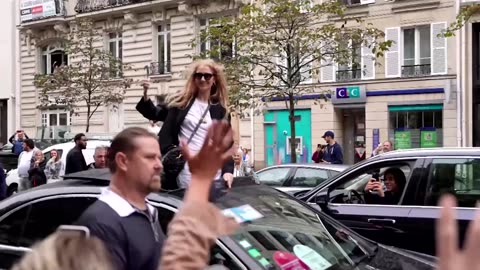 From the top of her car, Celine Dion waves goodbye to Paris