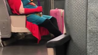 Man dressed as superman on train