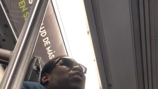 Man blue jacket singing on train