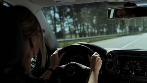 Blonde woman driving on road