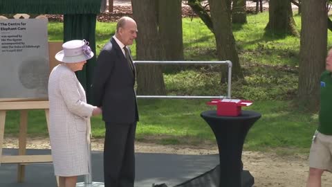 Queen and Duke of Edinburgh feed elephants bananas