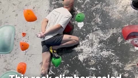 Climber scales rock wall with hands behind back