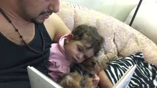 Beba y cachorro se quedan dormidos mientras les leen un cuento