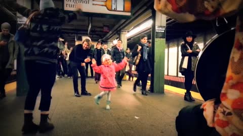 Little Girl Dances Along with Subway Performers