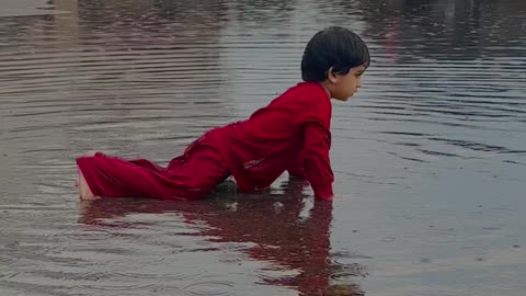 Kid Enjoying in Rain Water