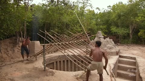 Building underground hut with grass roof & fireplace with clay