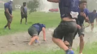 Football players jump into giant puddle after practice