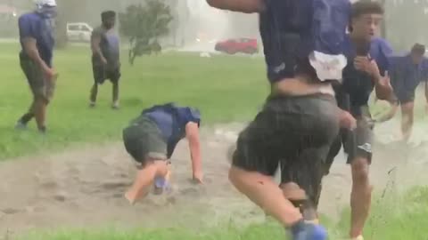 Football players jump into giant puddle after practice