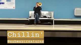 Guy playing trumpet in subway chillin