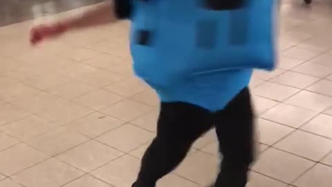 Man blue square costume spinning in train staion