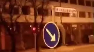 Drunk guy runs his head into blue arrow sign and falls down