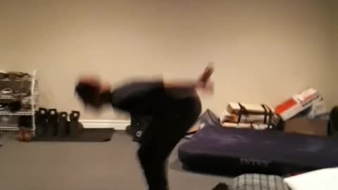 Music guy in black outfit and red hat tries to do backflip and fails