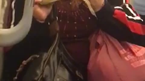 Woman eating corn on the cob on subway