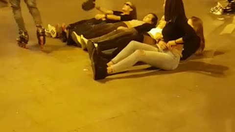 A group of guys jump over girls with a roller