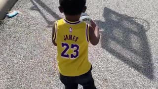 Watch this toddler drill a long distance basketball shot with ease