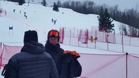 Skier skis into finish line and runs into red net, falls down
