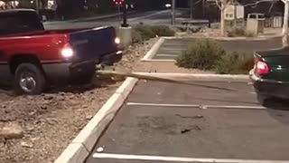 Small car helps pull out a truck that is stuck in a dirt pit