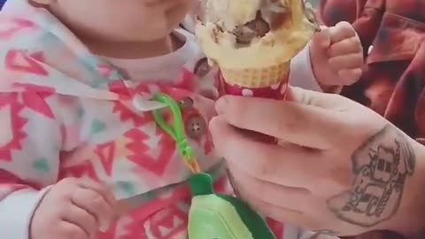 Cute baby eats ice cream for the first time